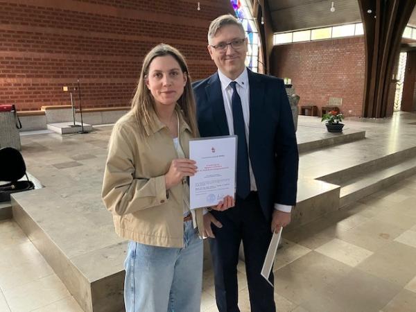 Ordinariatsrat Alexander Pfister überreicht Sandra Birklein die neue Missio Canonica-Urkunde.