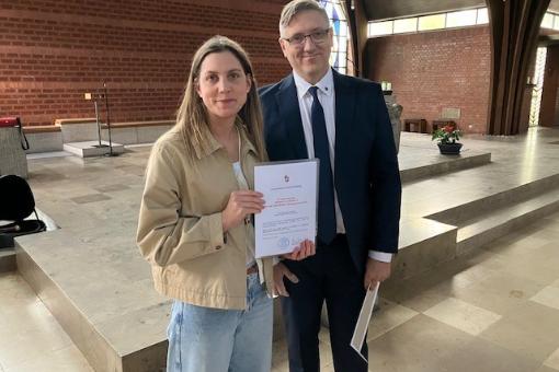 Ordinariatsrat Alexander Pfister überreicht Sandra Birklein die neue Missio Canonica-Urkunde.